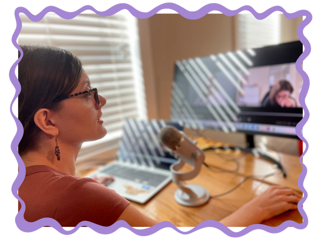 Olivia, a young white woman with brown hair and glasses, is sitting at her desk in front of her computer and podcast microphone, recording an episode.